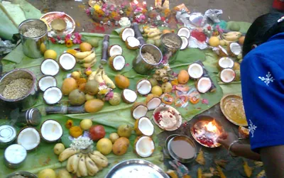 Fruits, coconuts, flowers and a lit lamp laid out on banana leaves to worship the Kaveri river at Tiruchirappalli