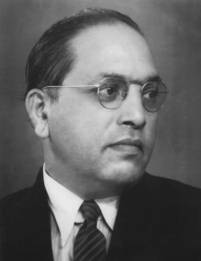 Black and white portrait of Dr B. R. Ambedkar in round glasses, suit and tie