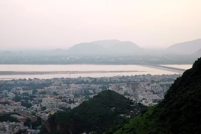 View over a city to a wide river and hills in the morning haze