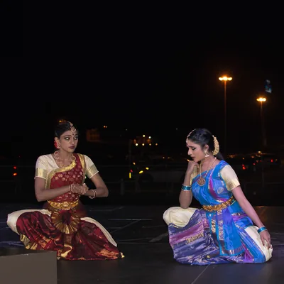 Two dancers kneeling on stage in classical poses