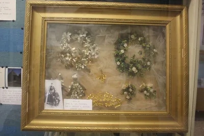 Old silver and golden wedding wreaths kept in a gilded glass case