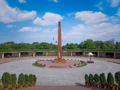 The tall pillar of the National War Memorial in New Delhi under a blue sky