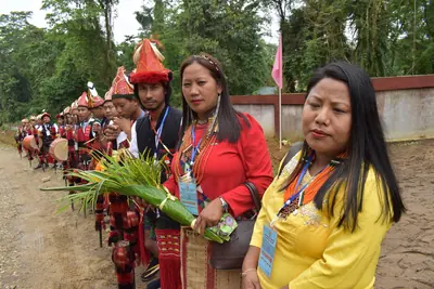People in traditional dress and headgear gathered outdoors for a celebration