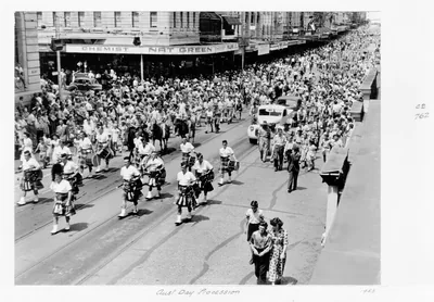Black and white photo of a long procession of marchers along a crowded city street