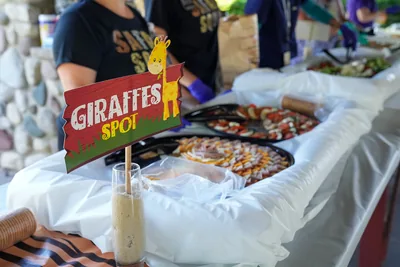 Party food and a giraffe sign on a table at a baby shower