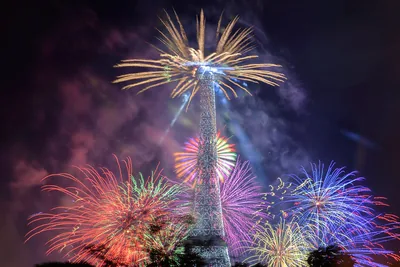 Fireworks bursting around the Eiffel Tower at night