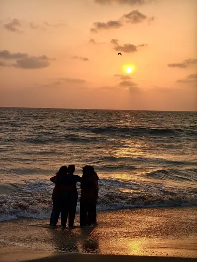 Friends silhouetted in the sea at sunset