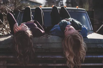 Two friends lying side by side in the back of a truck