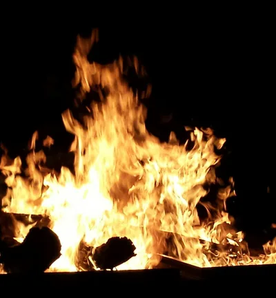 Bright orange flames of a Bhogi morning bonfire against a dark sky