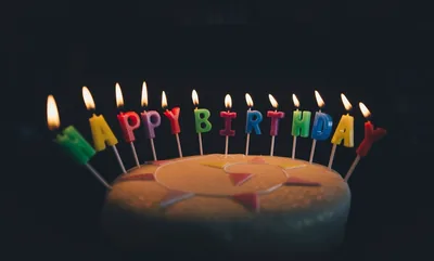 Birthday cake with glowing Happy Birthday candles