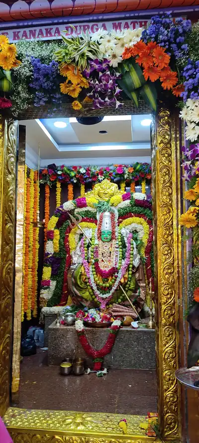 A goddess idol in a golden shrine decked with many flower garlands