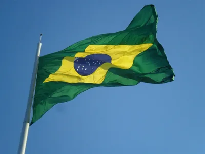 The flag of Brazil waving in a clear blue sky
