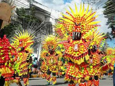 Dancers in huge spiky yellow and red costumes in a street parade