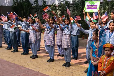 Schoolgirls in uniform standing in a row and waving flags in welcome