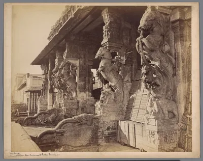 Old photo of a hall of carved stone pillars with mythical beasts