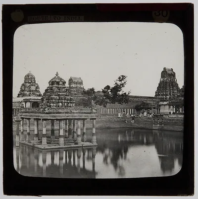 Old photo of a temple tank with a pillared pavilion and towers