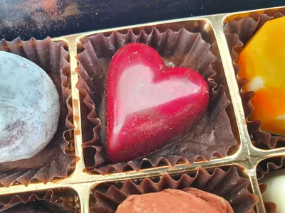 Glossy heart-shaped chocolates in a gift box