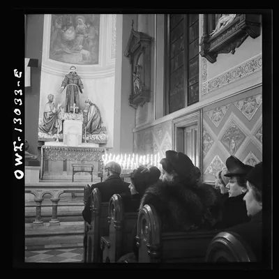 Black and white photo of people praying in a church at midnight Mass