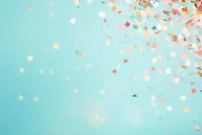 Colourful confetti falling against a soft teal background
