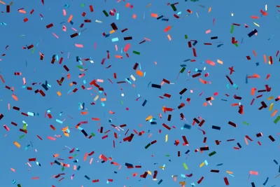 Colourful confetti against a blue sky