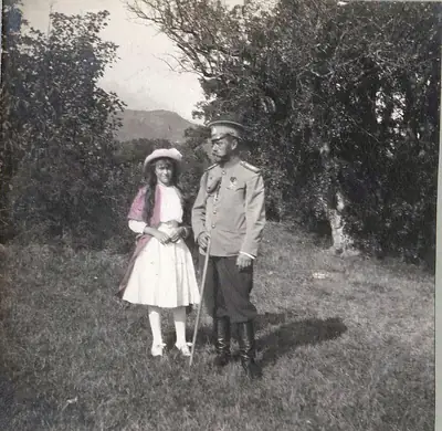 An old black and white photo of a father and his young daughter standing among trees