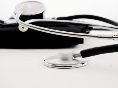 A black and silver stethoscope on a white desk