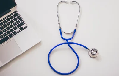 A blue stethoscope on a white desk
