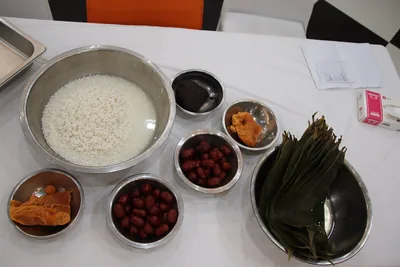 Bowls of sticky rice, red dates and bamboo leaves ready for wrapping zongzi