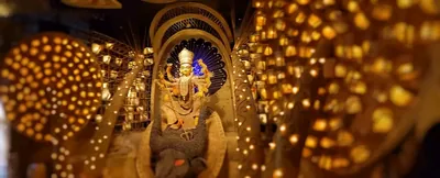 A golden pandal glowing with hundreds of small lights around an idol of the goddess