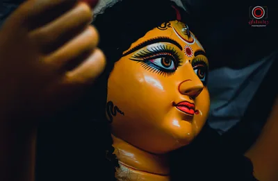 Close view of the painted face of a Durga idol with large eyes