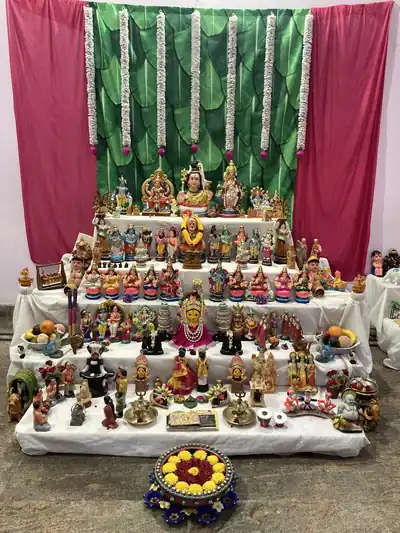 Steps covered in a white cloth holding rows of colourful dolls and figures of gods