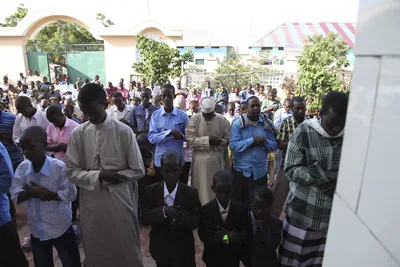 A crowd in festive clothes outside a mosque after prayer