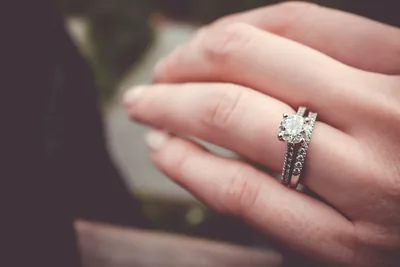 A hand wearing a sparkling diamond engagement ring