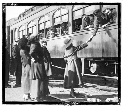 An old photo of people waving goodbye at a train