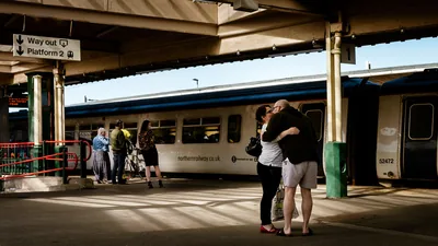 A couple hugging goodbye on a train platform