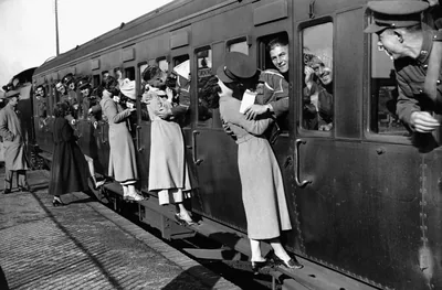 An old photo of people leaning from train windows to say goodbye