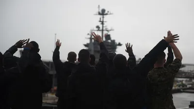Families waving as a big ship leaves port