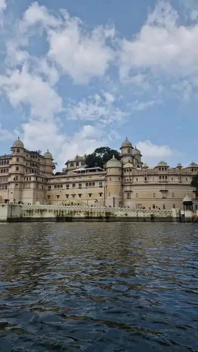 The cream coloured City Palace of Udaipur rising above the waters of Lake Pichola
