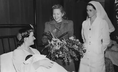 An old photo of a visitor bringing flowers to a hospital