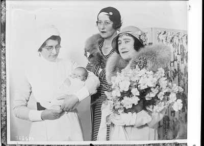 An old photo of visitors with flowers in a hospital