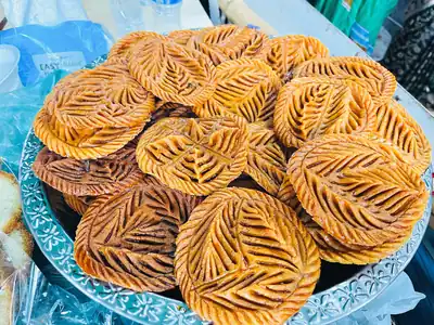 Golden fried sweets with a leaf pattern on a plate