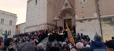 A procession with a cross on the steps of a stone church