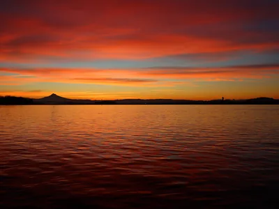 A red and orange sky over still water at dawn