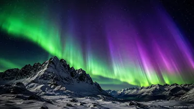 Green and purple northern lights over snowy mountains