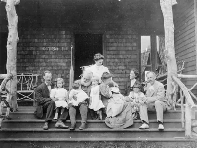 An old photo of a large family with grandparents on a porch