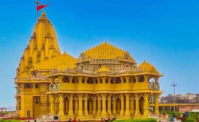 The golden Somnath Temple under a bright blue sky