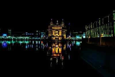 The Golden Temple glowing at night with its reflection in the water
