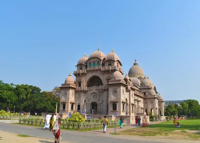 A large domed temple with lawns in front and visitors walking