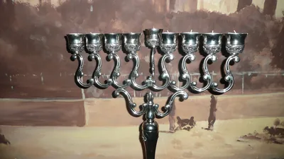 A silver menorah against a brick wall