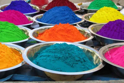Bowls heaped with bright blue, orange and green colour powder